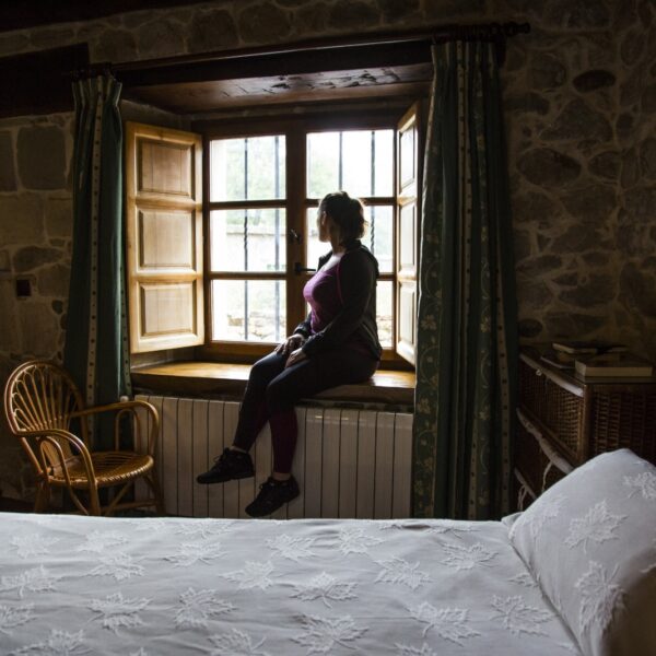 Mujer mirando por la ventana de una habitación